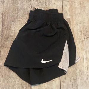 Black Nike running shorts. White mesh sides.